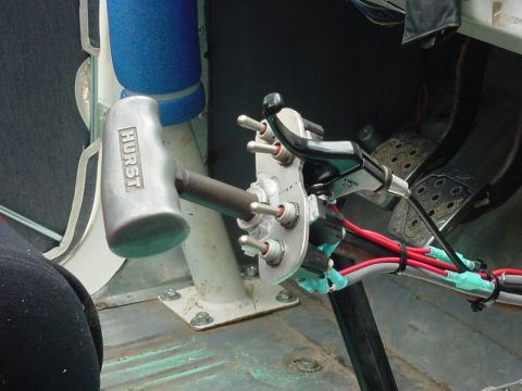 1969 Ford Bronco - Custom interior modifications a Hurst shifter and multiple toggle switches, with visible wiring and pedals.