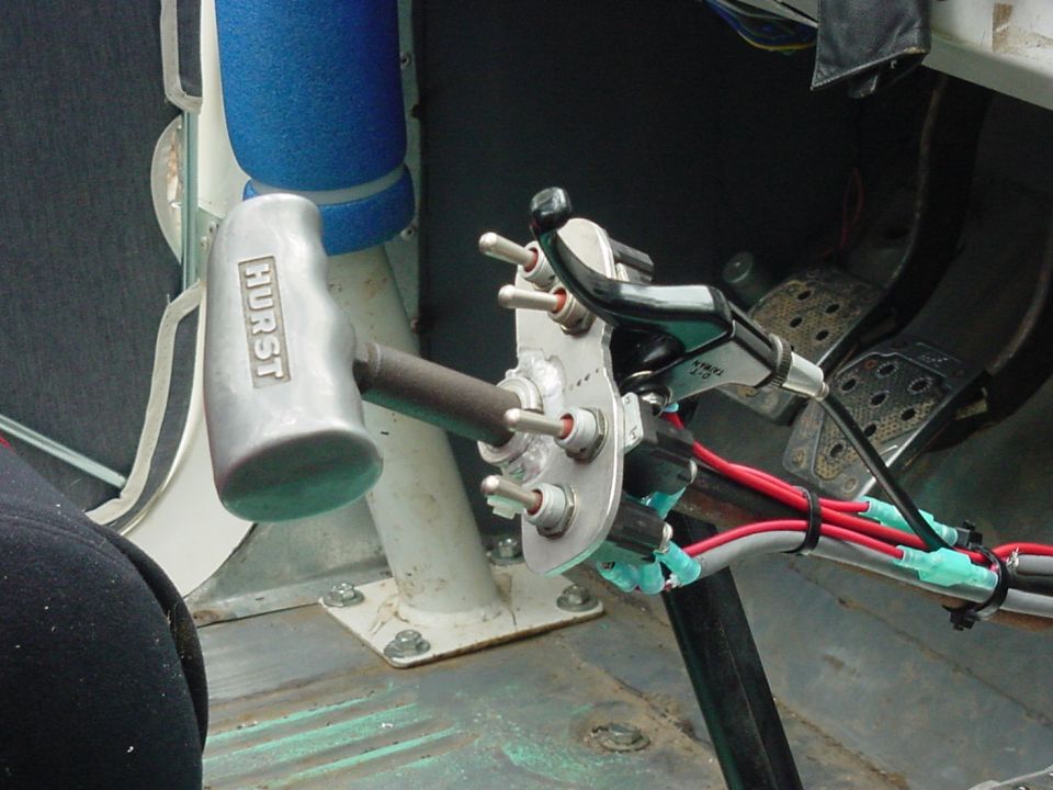Hurst shifter and toggle switches mounted on a metal plate inside a vehicle