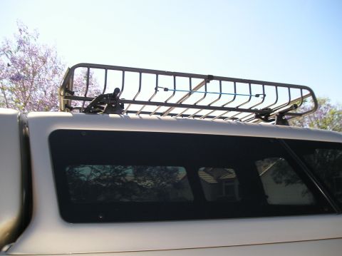 1999 Ford F-150 - A silver truck is equipped with a roof rack and a blue tie-down strap securing items.