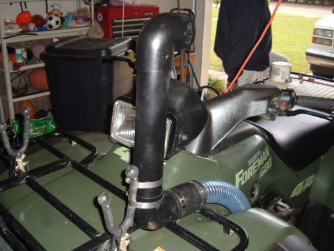 1978 Ford Bronco - An ATV is parked in a garage with a snorkel kit attached to its engine intake.