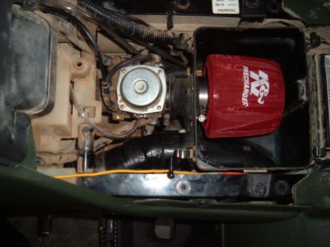 1978 Ford Bronco - Close-up of an engine compartment a K&N air filter and carburetor assembly.