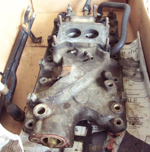 1985 Ford Crown Victoria LTD - A used intake manifold, likely from a Ford vehicle, is shown in a cardboard box.