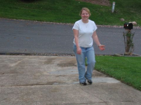 1985 Ford Crown Victoria LTD - A woman walks across a driveway in front of a grassy lawn and a mailbox.