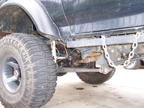 1994 Ford F-150 - Close-up view of the front axle and suspension components of a modified truck.