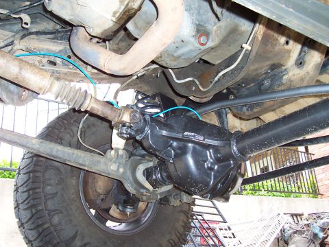 1994 Ford F-150 - Undercarriage view of front axle and suspension components, including the driveshaft and a tire.