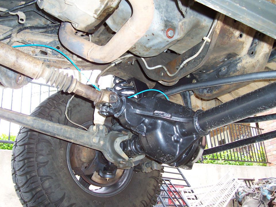Front axle and suspension parts with driveshaft and tire