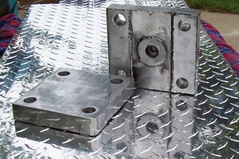 1994 Ford F-150 - Metal brackets with bolt holes sit on a diamond plate surface.