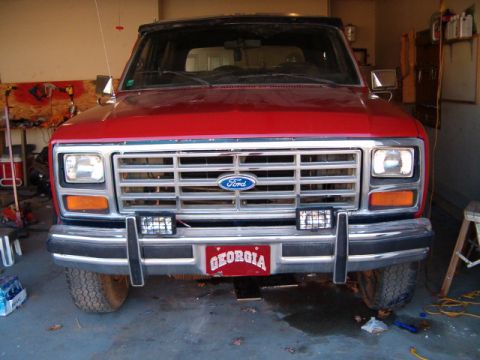 1985 Ford Bronco - Front view of a red Ford Bronco, likely from the early 1980s, parked indoors.