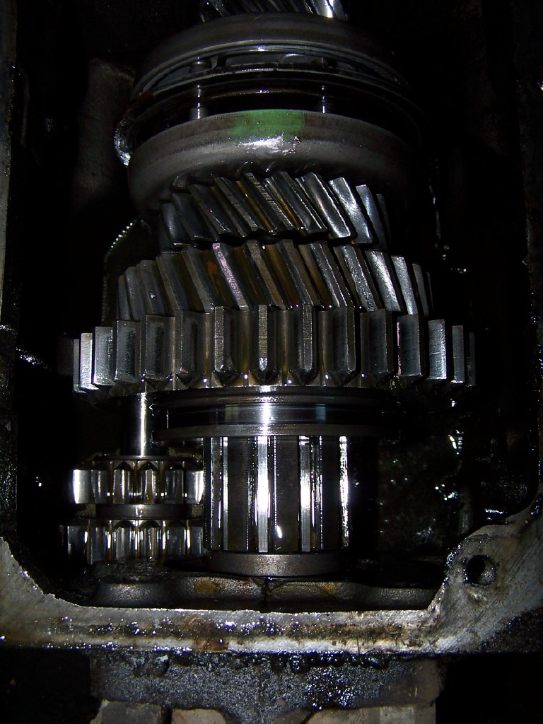 Close-up of stacked helical gears and shaft inside an open transmission case