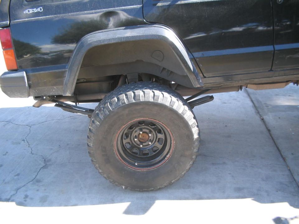 1994 Jeep Cherokee rear wheel, leaf spring suspension, and 4x4 badge