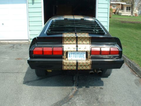 1978 Ford Mustang II - Rear view of a black 1978 Ford Mustang II with distinctive gold stripes and a custom license plate.