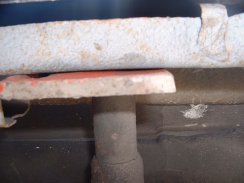 1978 Ford Mustang II - Close-up of vehicle undercarriage components, including an exhaust pipe and a red bracket.