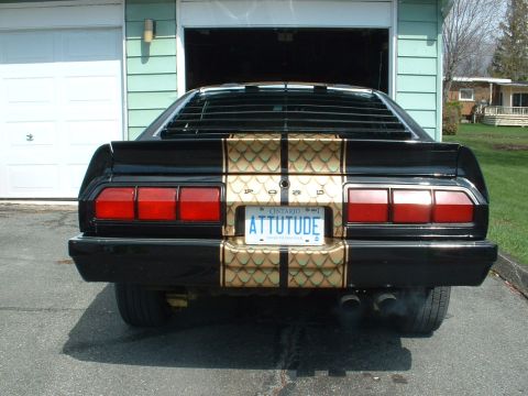 1978 Ford Mustang II - This black car features distinctive gold scale-patterned stripes and a personalized Ontario license plate reading 'ATTITUDE'.