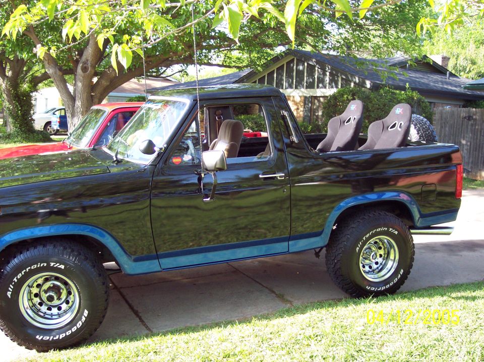 Side view of black 1986 Ford Bronco with racing seats and off-road tires