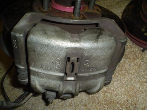 1993 Ford Taurus - A close-up view of a Ford brake caliper, showing part numbers and the Ford logo.