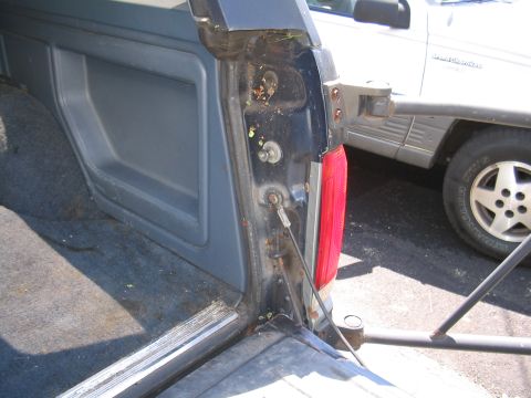 1979 Ford Bronco - The interior of a dark blue SUV shows wear and tear, with a silver SUV visible in the background.