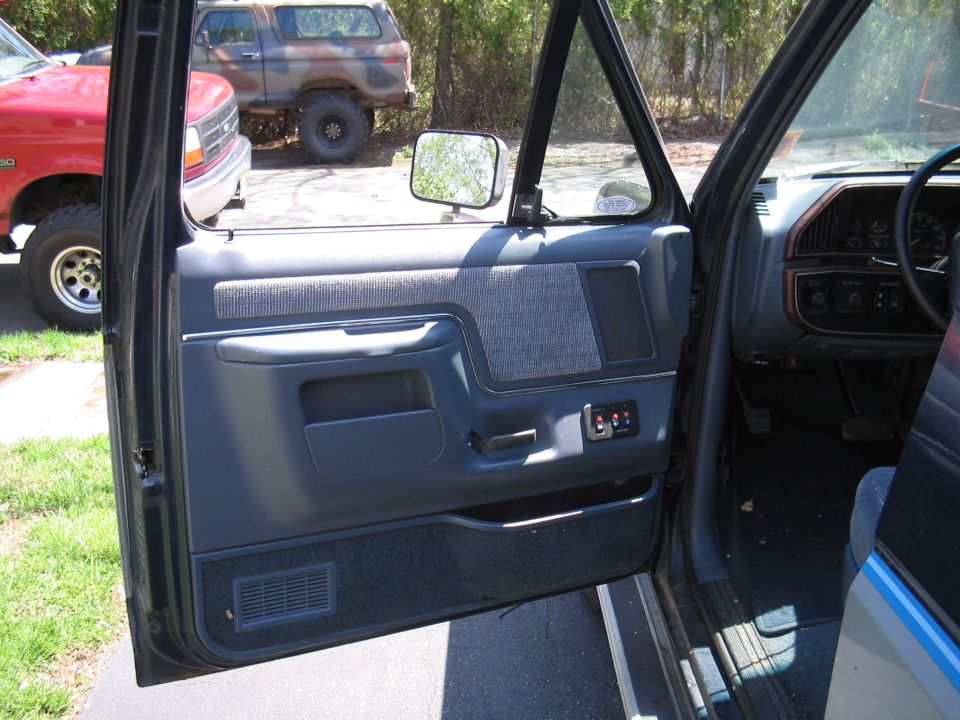 Interior door panel and dashboard of a vehicle, with another vehicle visible outside