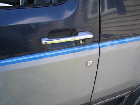 1979 Ford Bronco - Close-up of a two-tone vehicle door, showing the handle and lock mechanism.