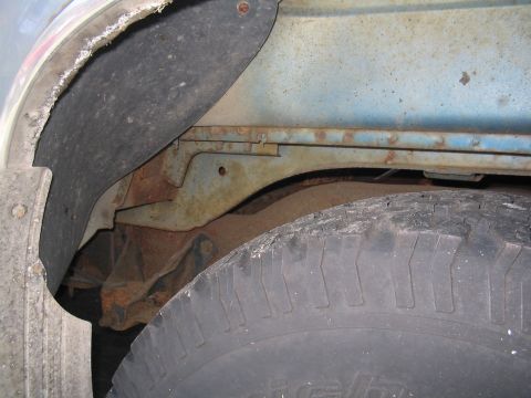 1979 Ford Bronco - Detail shot of the rear wheel well and frame, revealing rust and wear on the vehicle's undercarriage.