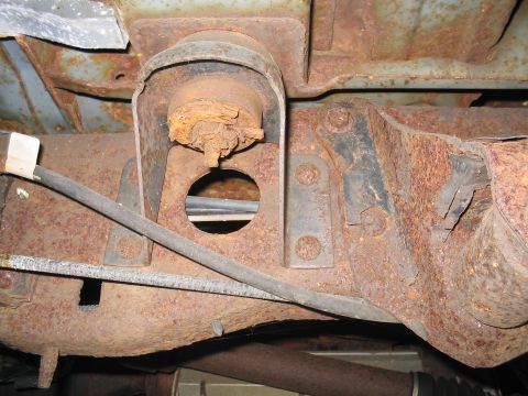 1979 Ford Bronco - The underside of a vehicle shows significant rust on the frame and suspension parts.
