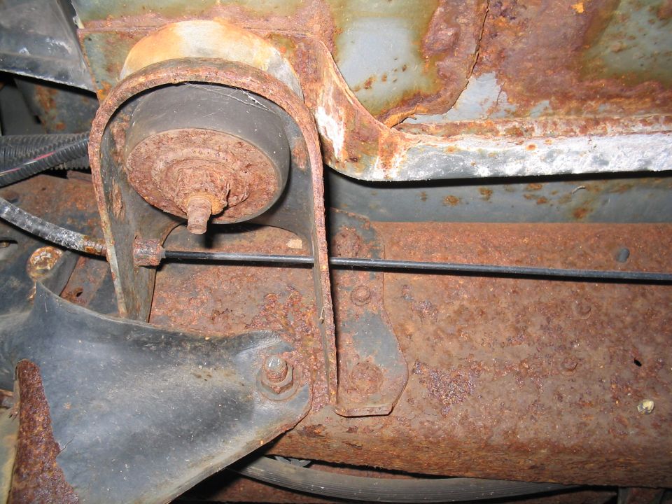 Heavily rusted frame bracket and suspension component with visible Supermotors.net watermark