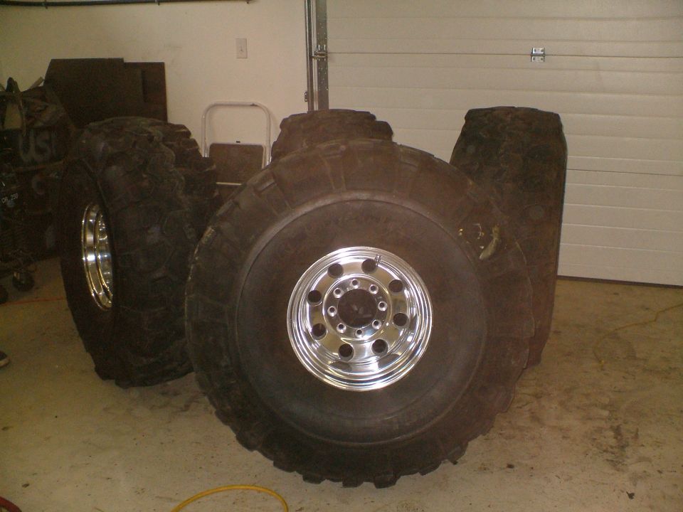 Four large off-road tires with chrome rims