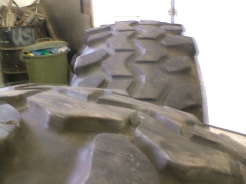 1995 Ford F-150 - Close-up view of aggressive tread patterns on large off-road tires stored indoors.