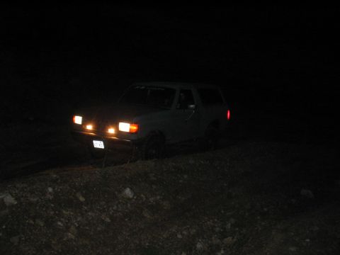 1991 Ford Bronco - A 1991 Ford Bronco is seen at night with its headlights illuminated.