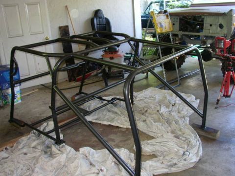 1995 Ford Bronco - Roll cage assembly in a garage, with a car seat in the background.