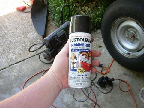 1995 Ford Bronco - A can of spray paint is held in front of a car wheel and some electrical equipment.