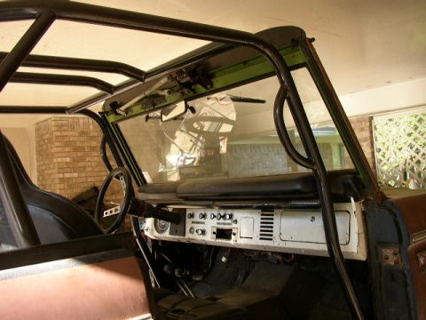 1995 Ford Bronco - The interior of a Ford Bronco, modified with a roll cage, is visible from the driver's side.