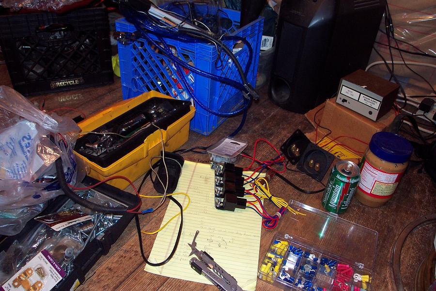 Underhood wiring, relays, and parts laid out on a floor