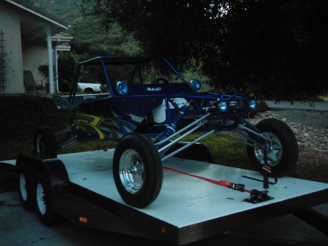 1978 Ford Bronco - Custom blue dune buggy secured to a trailer, ready for transport.