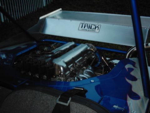 1978 Ford Bronco - Custom vehicle engine bay a V-twin engine and a TRICK racing gasoline sticker.