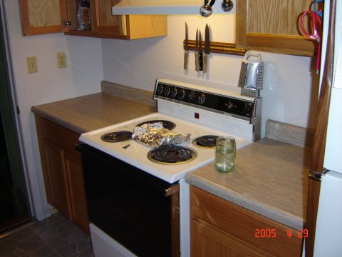 1993 Ford Bronco - A kitchen scene a white electric stove with food covered in foil, a glass of water, and a knife rack on the wall. The date "2005 11 29" and…