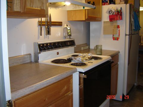 1993 Ford Bronco - Interior view of a kitchen showing a stove, refrigerator, and cabinets.