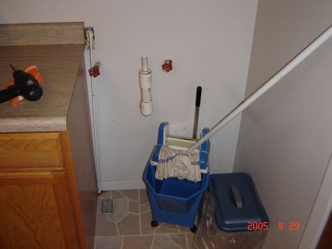 1993 Ford Bronco - Utility sink area with cleaning supplies and a drill on the counter.