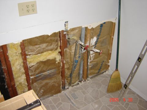 1993 Ford Bronco - Kitchen renovation shows exposed wall studs, insulation, and plumbing with a broom and level.