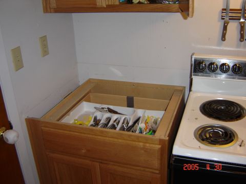 1993 Ford Bronco - A kitchen scene shows an open cabinet drawer with silverware and a white electric stove.