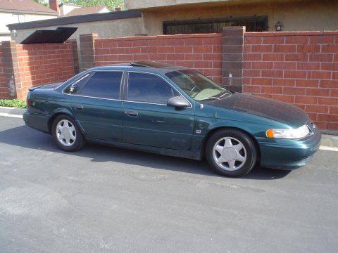 1993 Ford Taurus - This 1993 Ford Taurus sedan is parked outside a brick building.