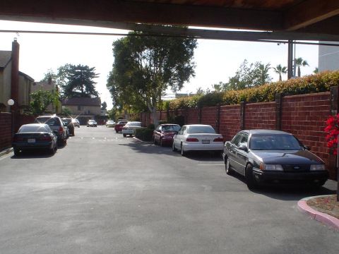1993 Ford Taurus - Several cars are parked in a lot, with a dark sedan in the foreground.
