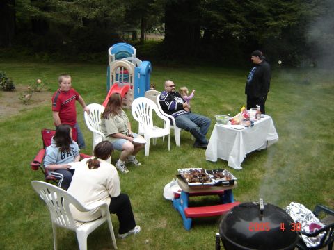 1993 Ford Bronco - A family enjoys a barbecue in the backyard with a playground nearby.
