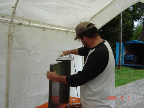 1993 Ford Bronco - Man ironing a granite slab outdoors. A blue container is visible in the background.