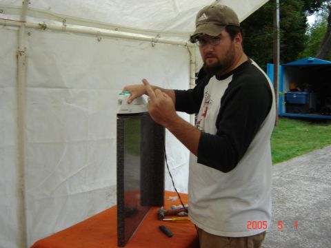 1993 Ford Bronco - A man appears to be ironing a granite slab under a tent, with a blue storage unit in the background.