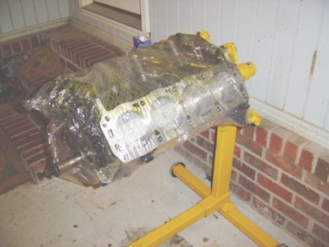 1986 Ford Bronco - Engine block on a stand, wrapped in plastic, ready for transport or storage.