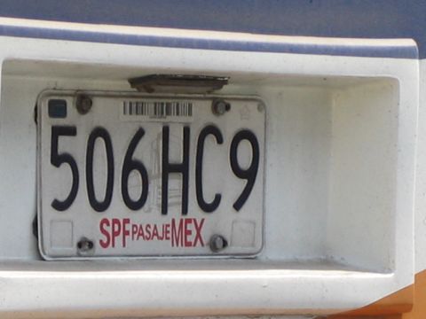 1985 Ford Mustang - The rear of a white vehicle displays a Mexican license plate with the alphanumeric code 506HC9.