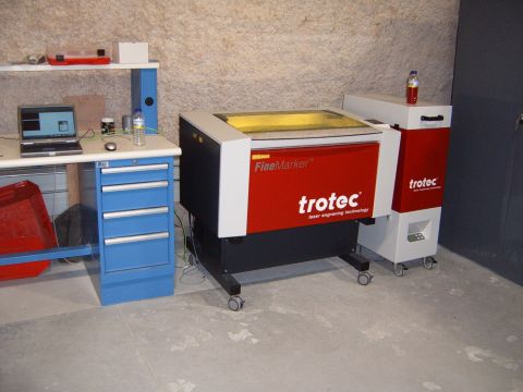 1988 Ford Bronco - A Trotec laser engraver is set up next to a workbench with a laptop.