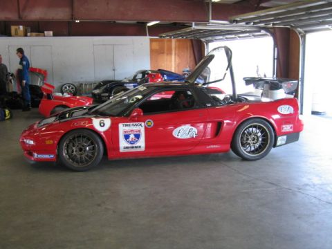 1991 Ford LTD Crown Victoria - A red Acura NSX race car is parked in a garage, with its doors open and a roll cage visible.