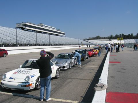 1991 Ford LTD Crown Victoria - Cars are lined up on a race track with a grandstand in the background.