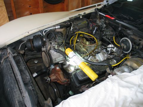 1981 Chevrolet Corvette - The engine bay of a 1981 Chevrolet Corvette is shown with a yellow work light focused on the carburetor.